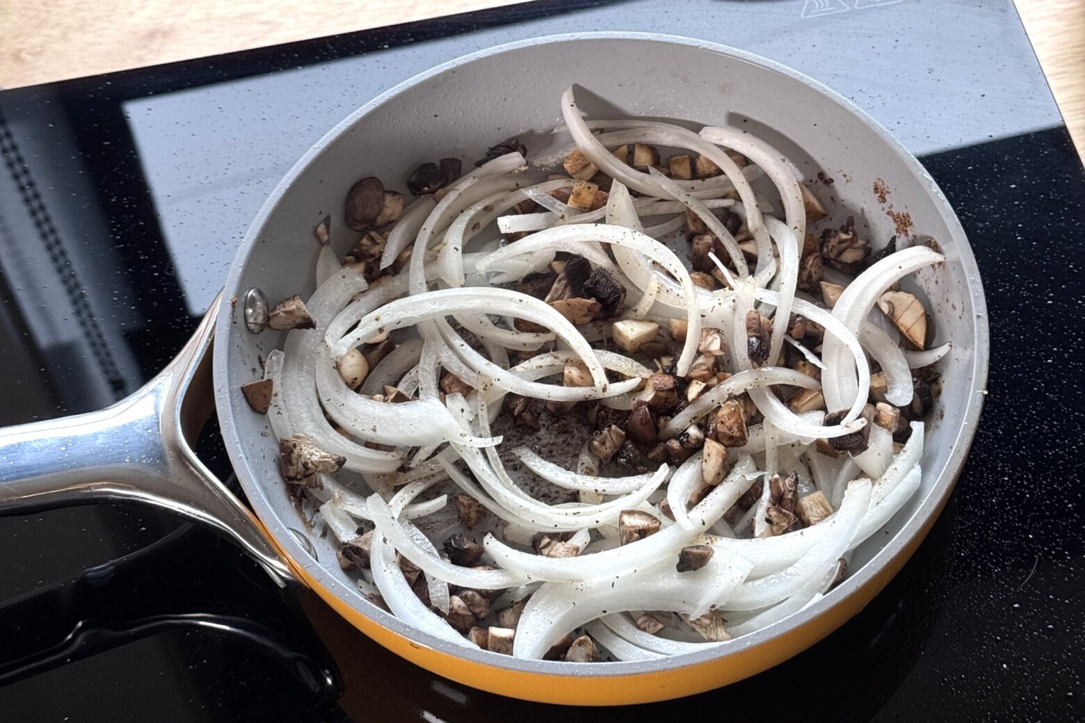 Mushrooms and onion in a pan.