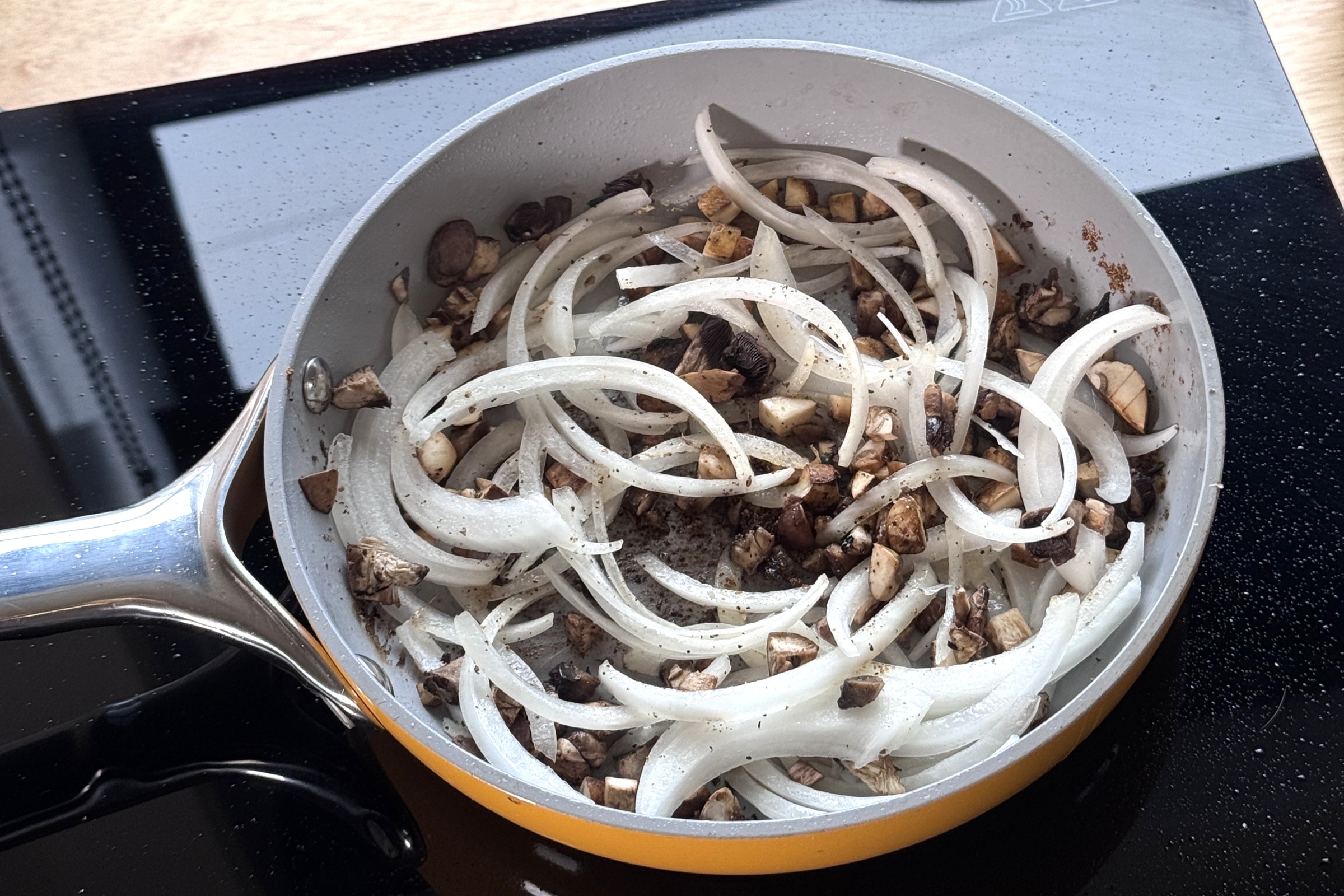 Mushrooms and onion in a pan.