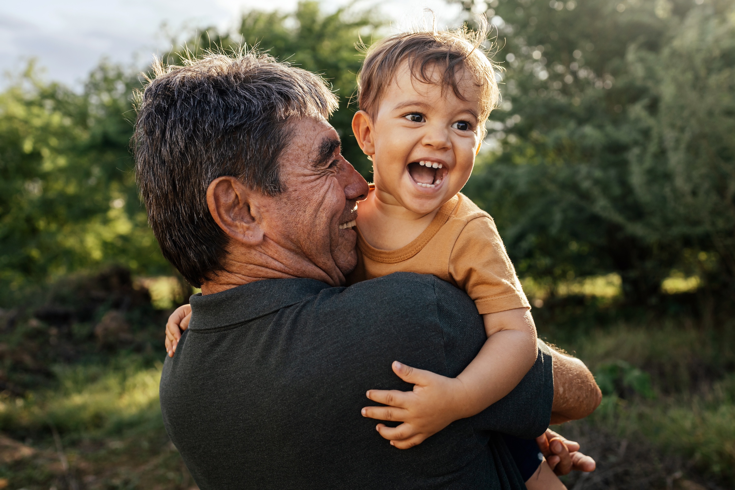 Grandfather playing with his grandson outside.