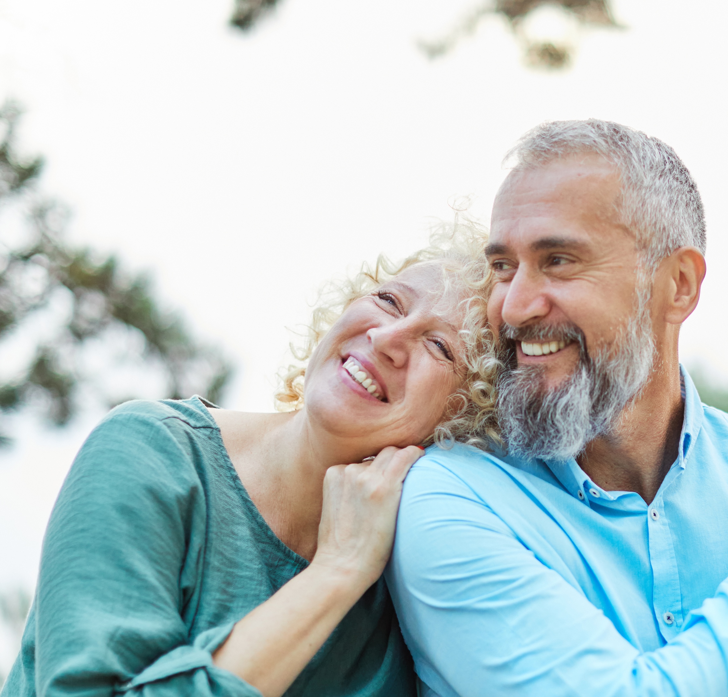 Couple sitting outside, looking happy.