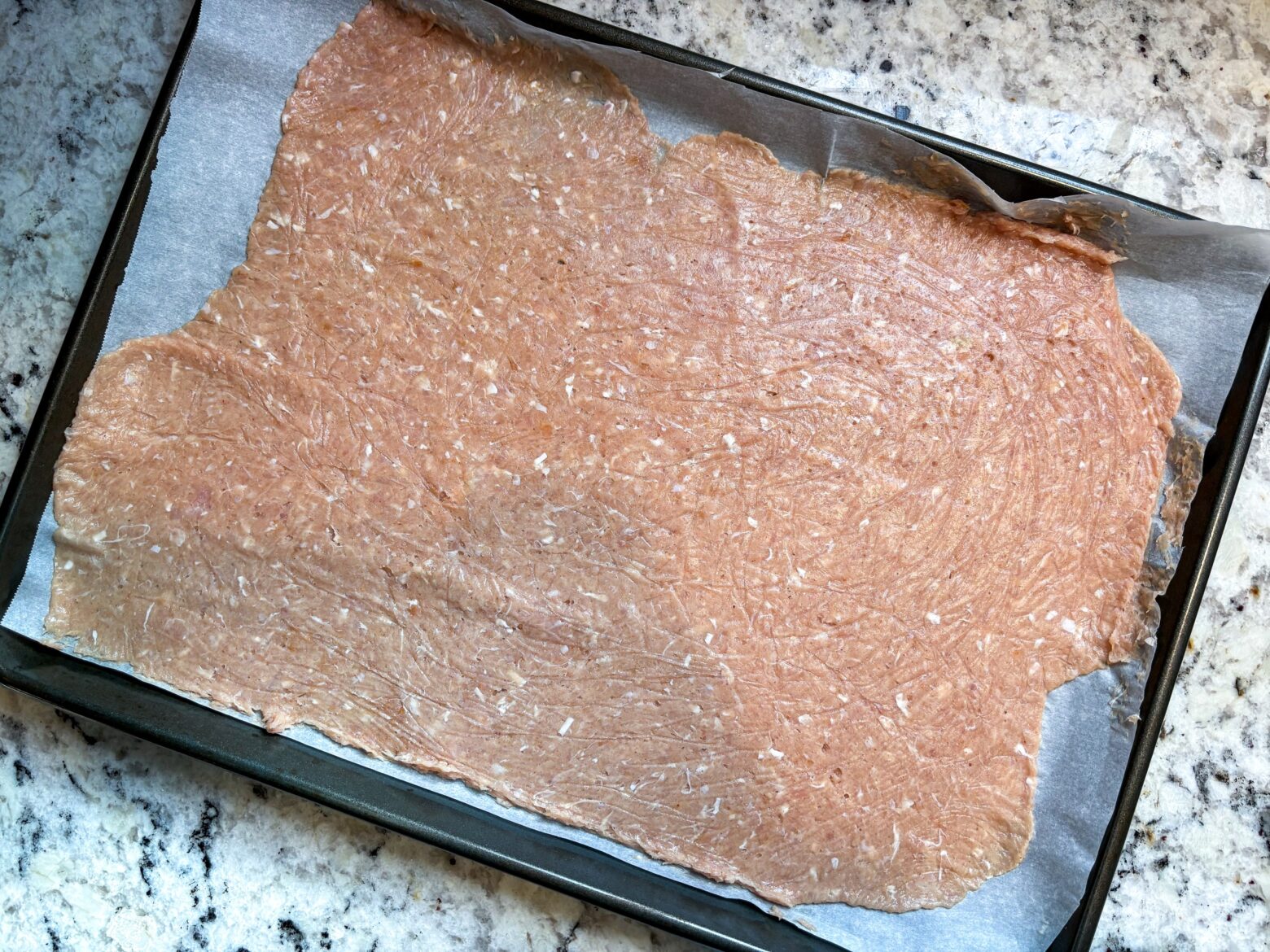 Raw chicken chip mixture on a baking sheet.