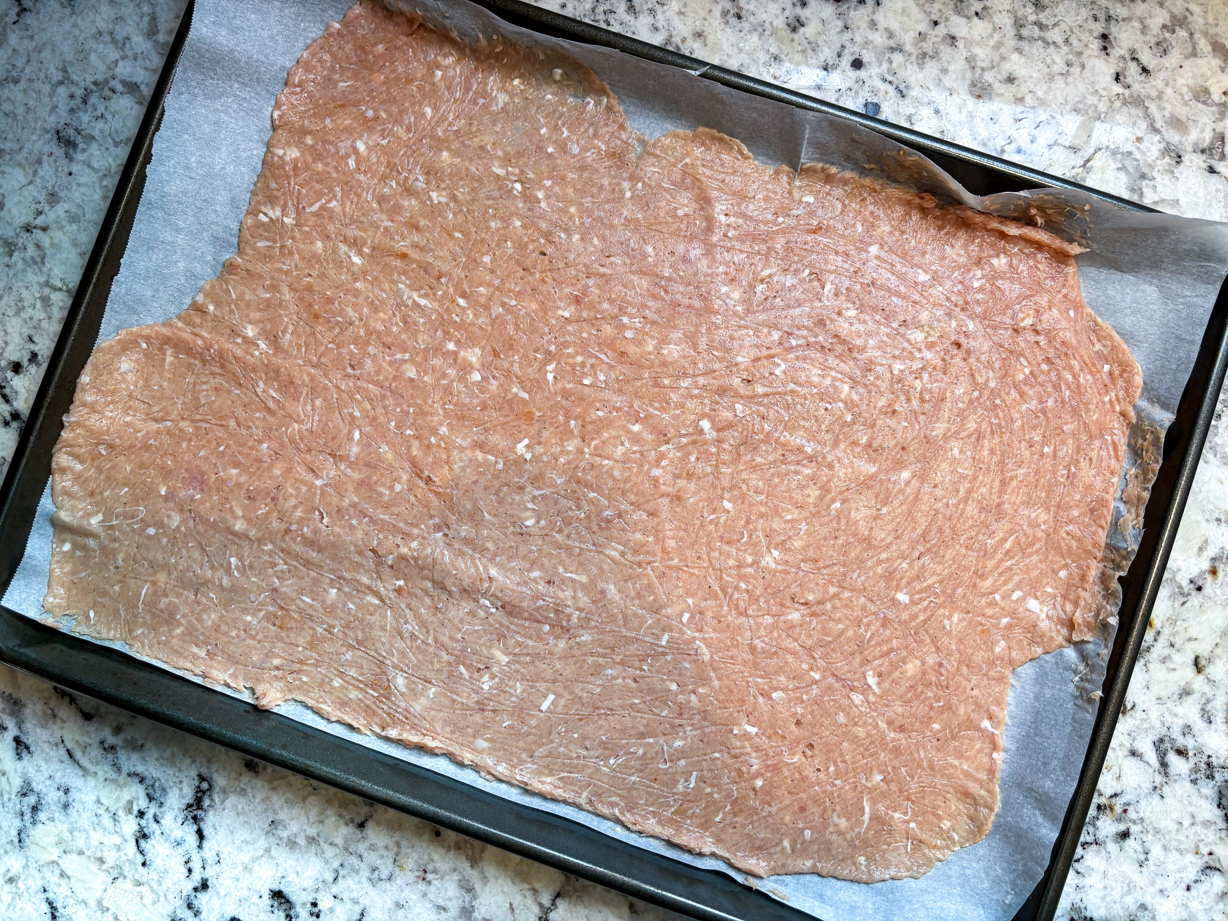 Raw chicken chip mixture on a baking sheet. 