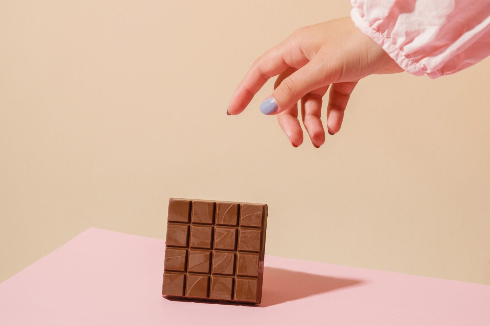 A hand reaching from out of shot for a chocolate bar.