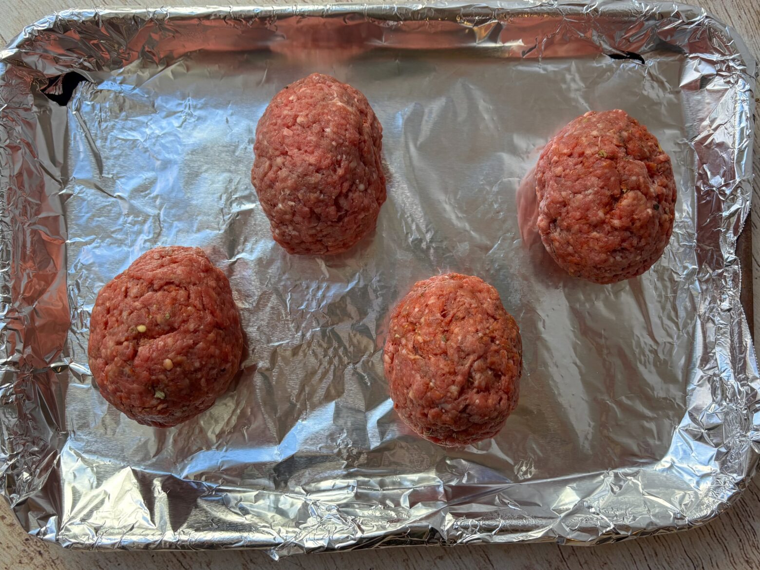 Scotch eggs on a pan before baking