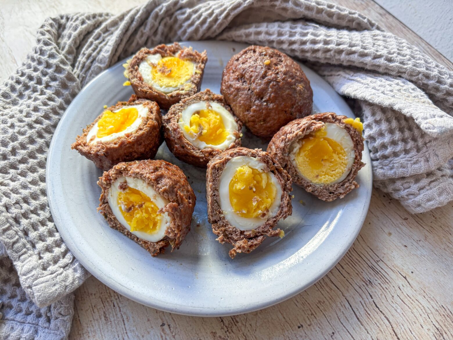 Baked Scotch Eggs cut open on a plate