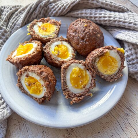 Baked Scotch Eggs cut open on a plate