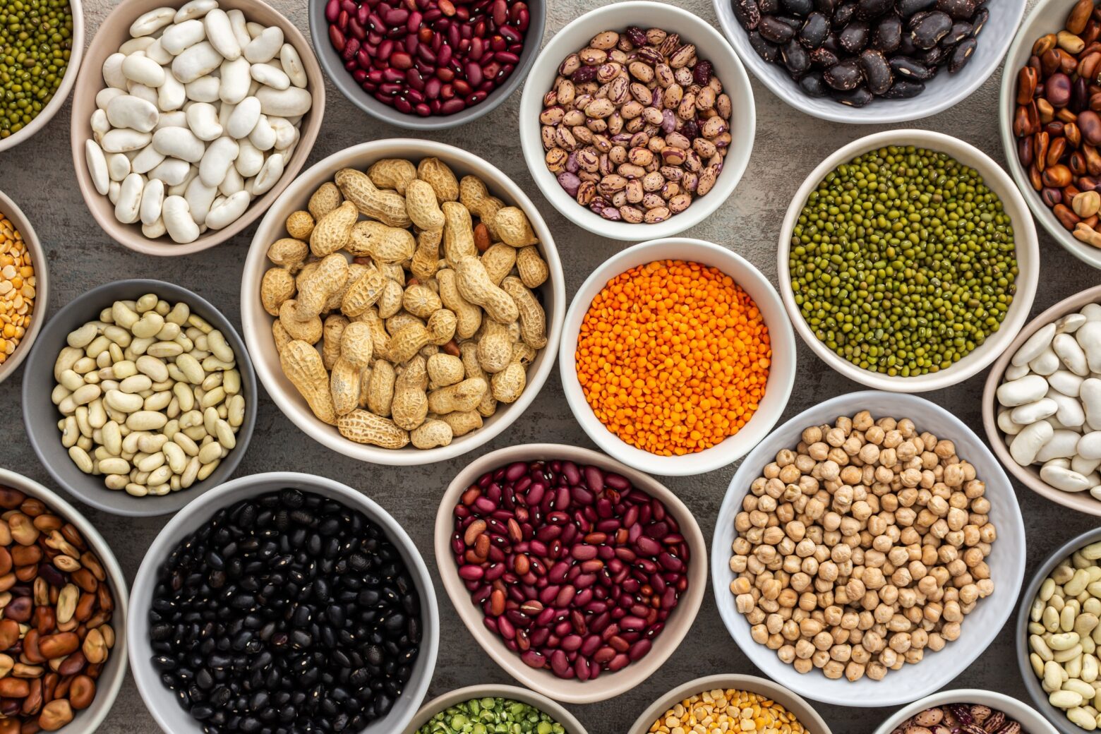 Above shot of various beans and legumes in different bowls.