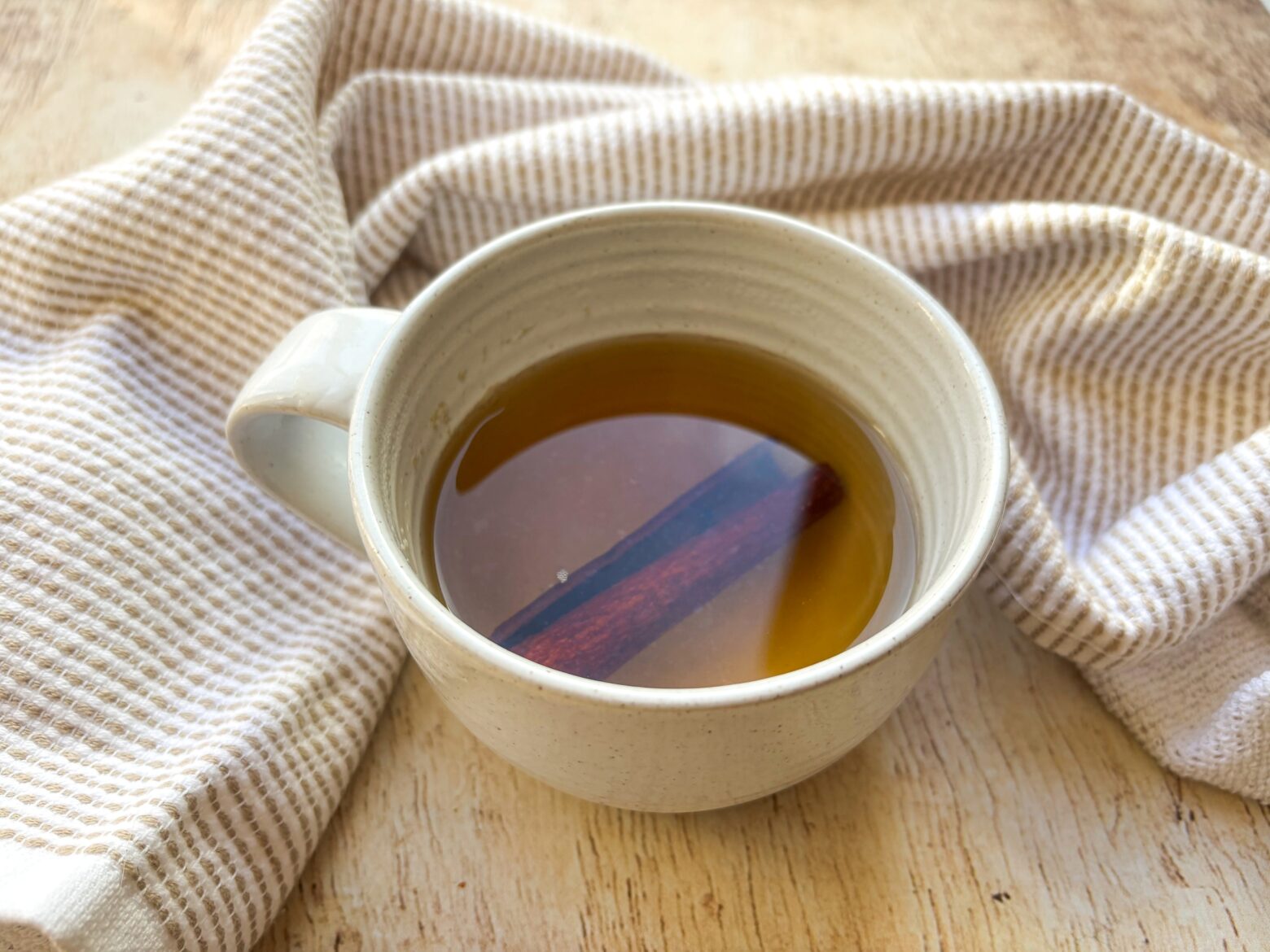 Chamomile Cinnamon Tea in a mug with a cinnamon stick.