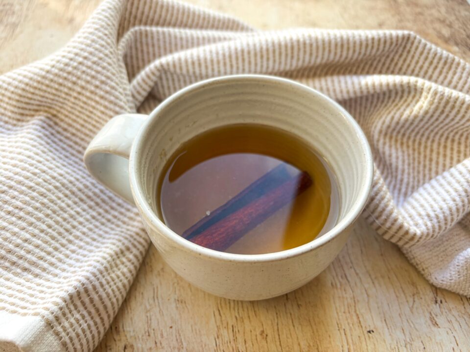 Chamomile Cinnamon Tea in a mug with a cinnamon stick.