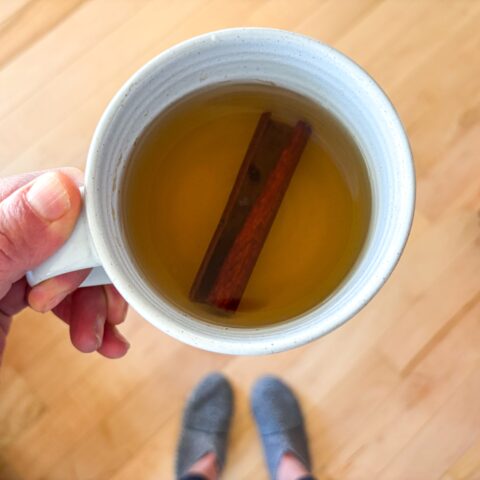 Chamomile Cinnamon Tea in a mug with a cinnamon stick.