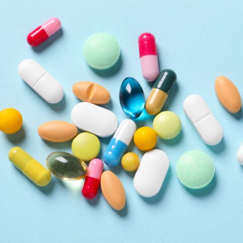 Colorful assortment of supplements on a light blue background.