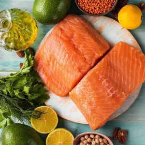 Salmon fillets surrounded by lemon, dill, and oil.