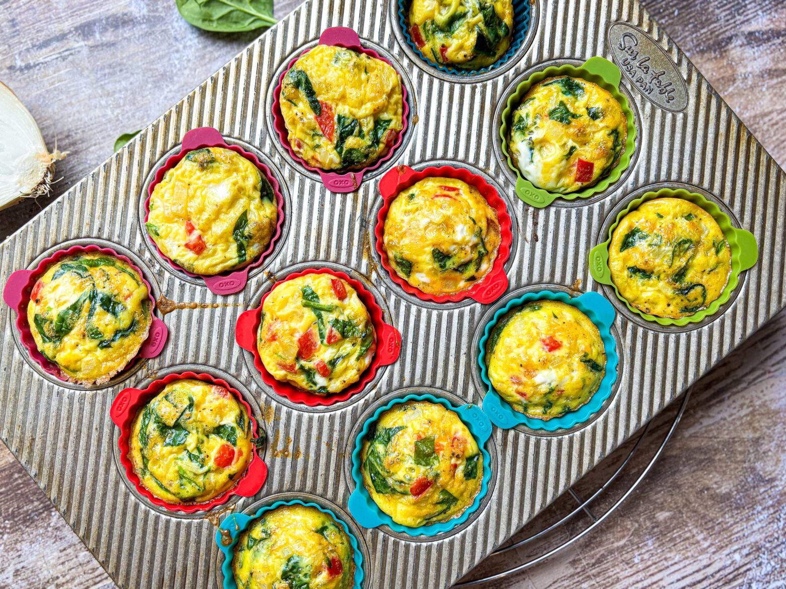 Cooked Red Pepper & Spinach Egg Bites in a muffin tin.