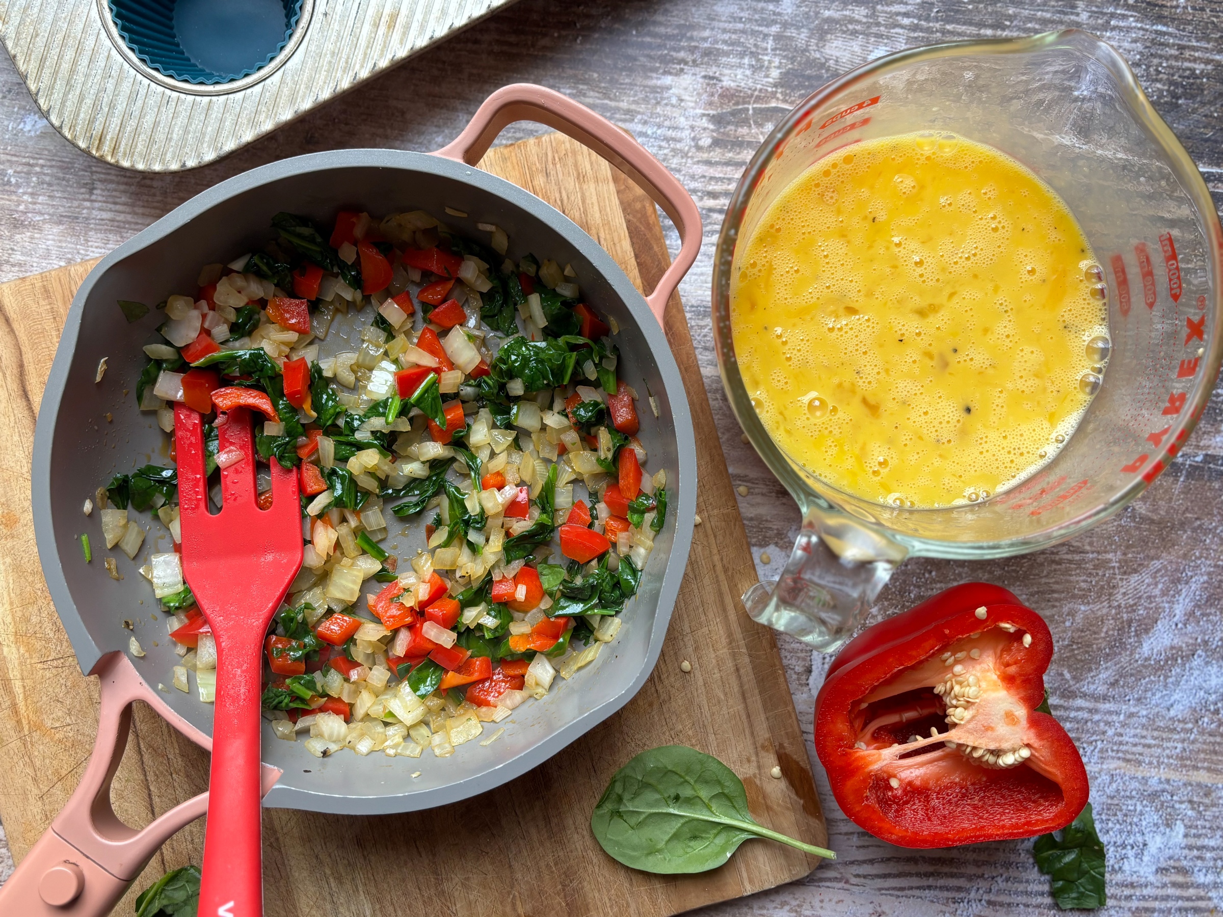 Cooked veggies and egg batter for Red Pepper & Spinach Egg Bites.
