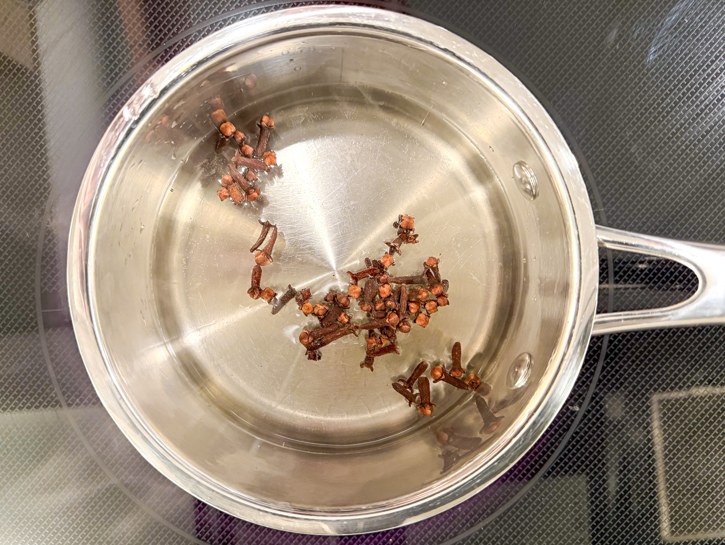 Heating cloves, water, and honey for Jasmine Green Tea Lattes.