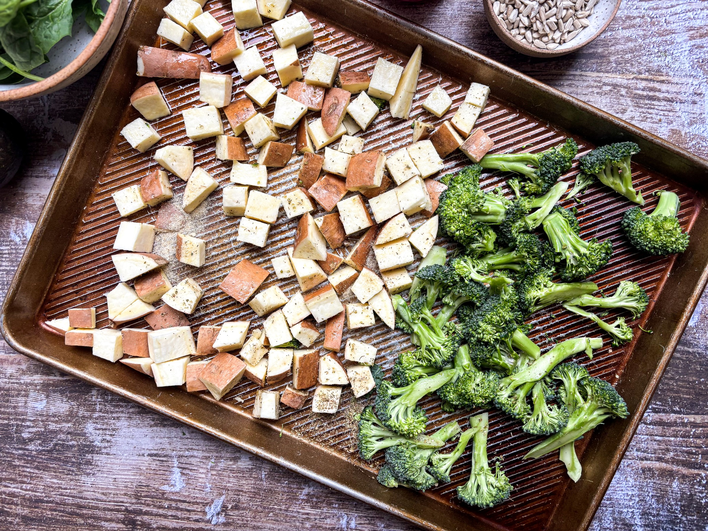 Chopped sweet potato and broccoli on a baking sheet.