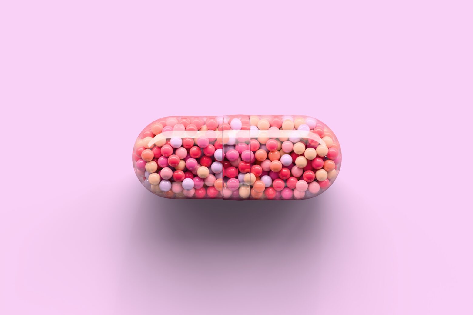 Transparent capsule with colorful spherules inside.