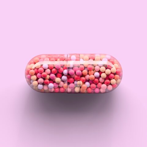 Transparent capsule with colorful spherules inside.