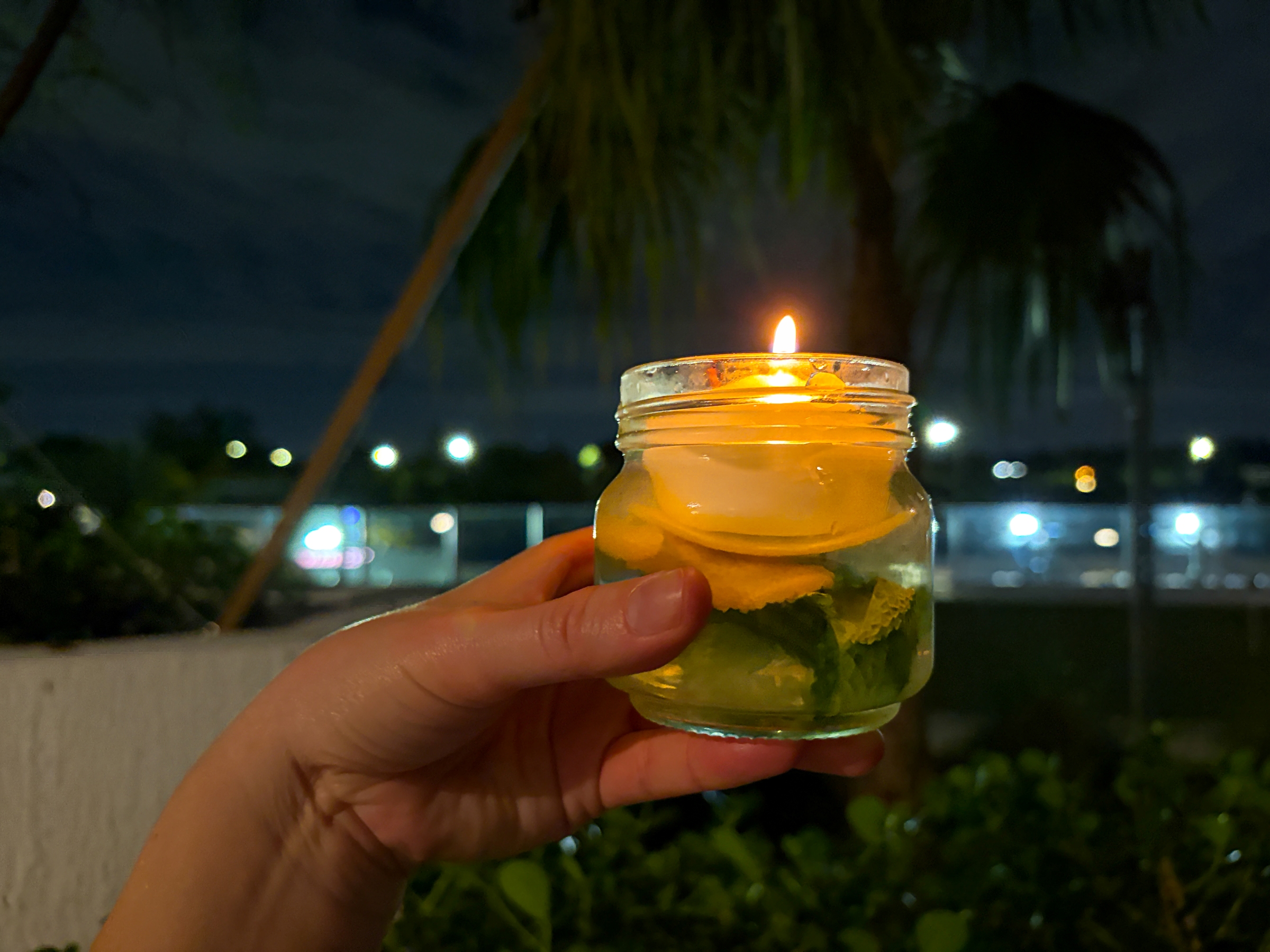 Finished bee and wasp repellent candle lit at night.