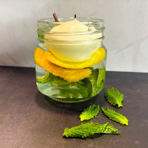 Finished bee and wasp repellent candle with a tea light floating in the water.