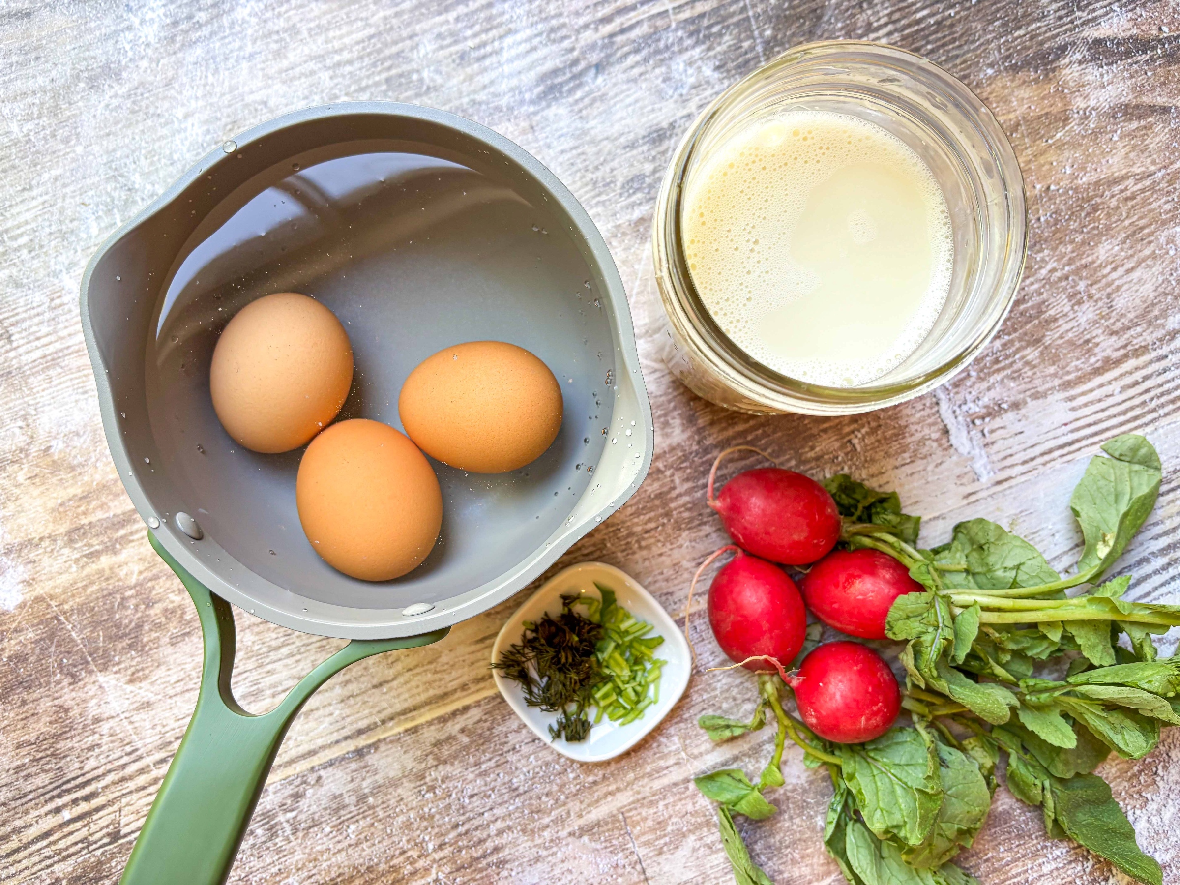 Hardboiled eggs next to radishes and almond milk
