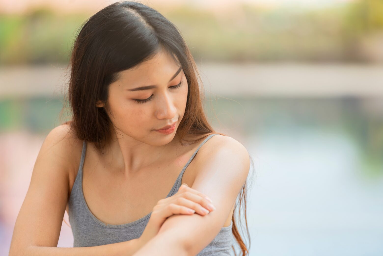 Woman looking at the skin on her arm.