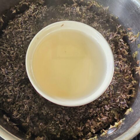 Lavender hydrosol in pot with distilled lavender flowers