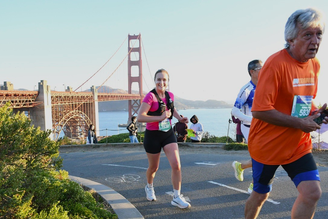 Author smiling while running up a hill overlooking the Golden Gate Bridge.