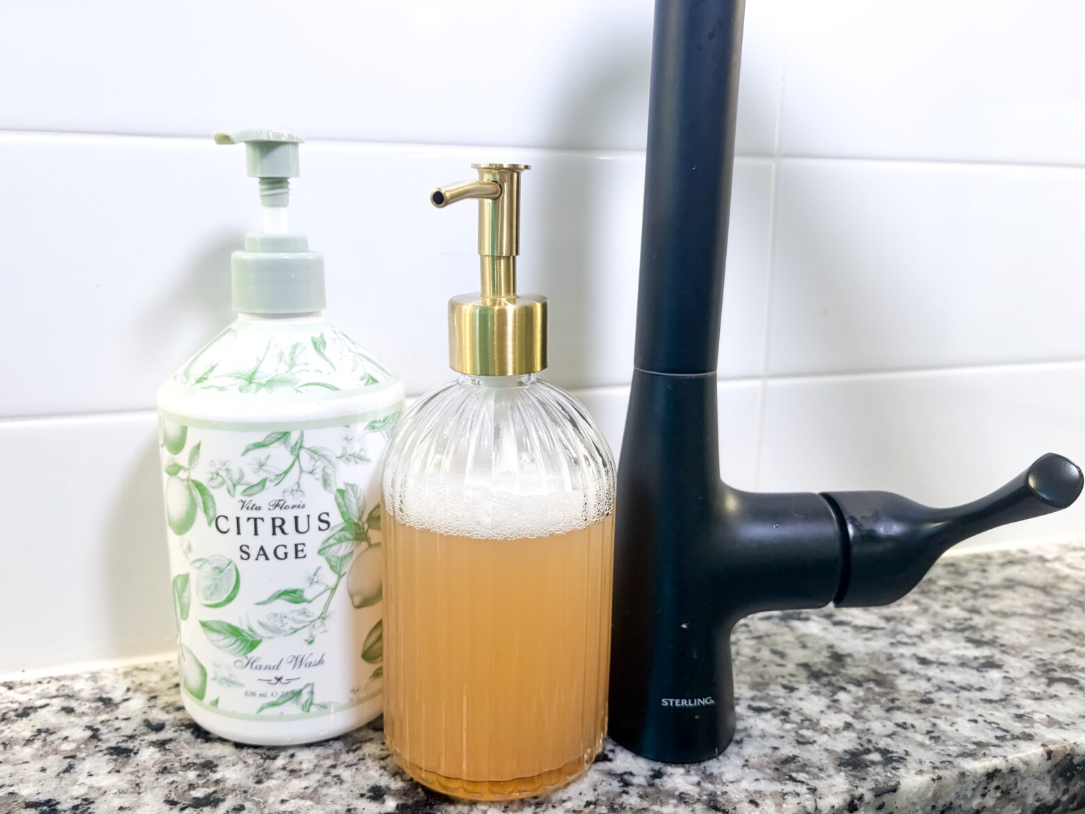 Two soap dispensers on a kitchen sink.