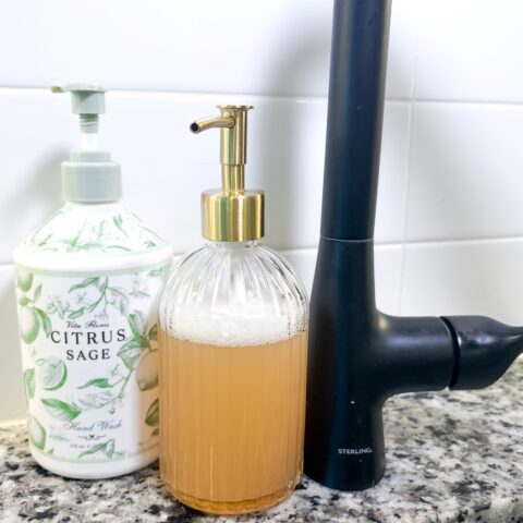 Two soap dispensers on a kitchen sink.