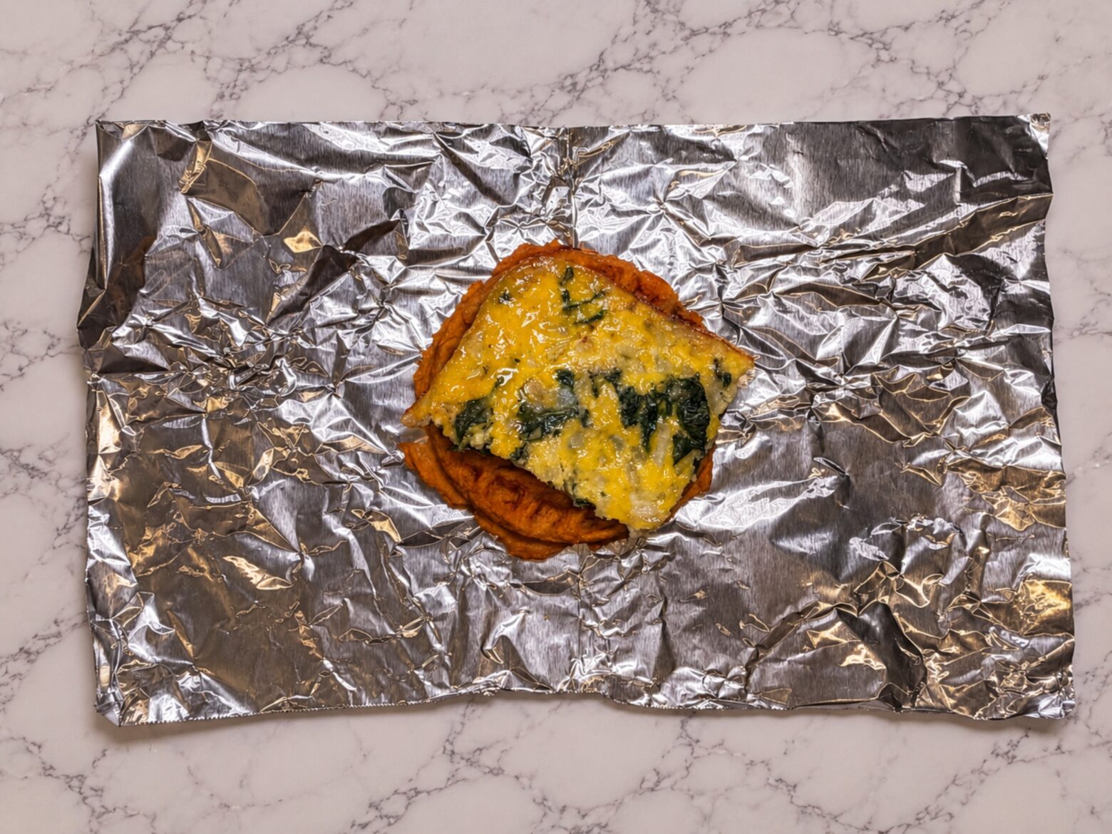 Egg square on top of a sweet potato waffle.