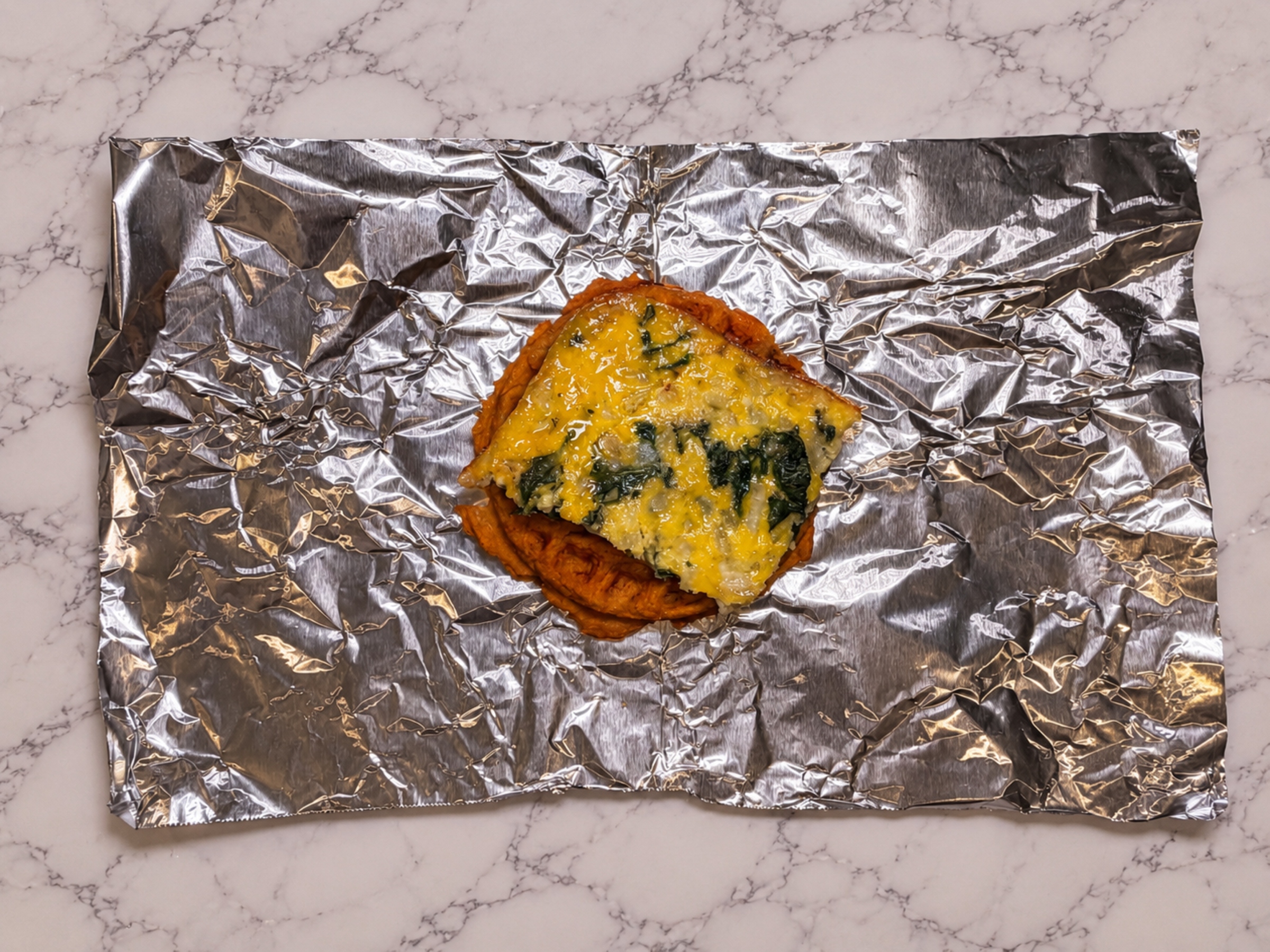 Egg square on top of a sweet potato waffle.