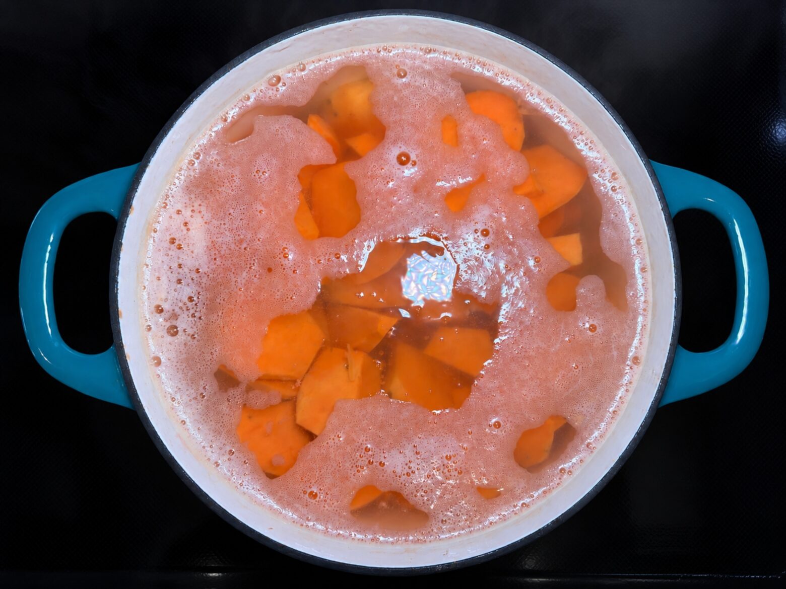 Sweet potatoes boiling in a pot.